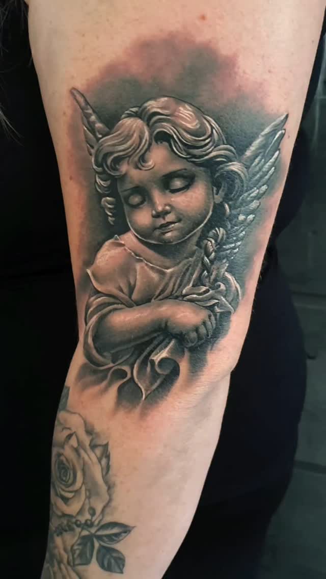 Realistyczny tatuaż śpiącego anioła w technice black and grey